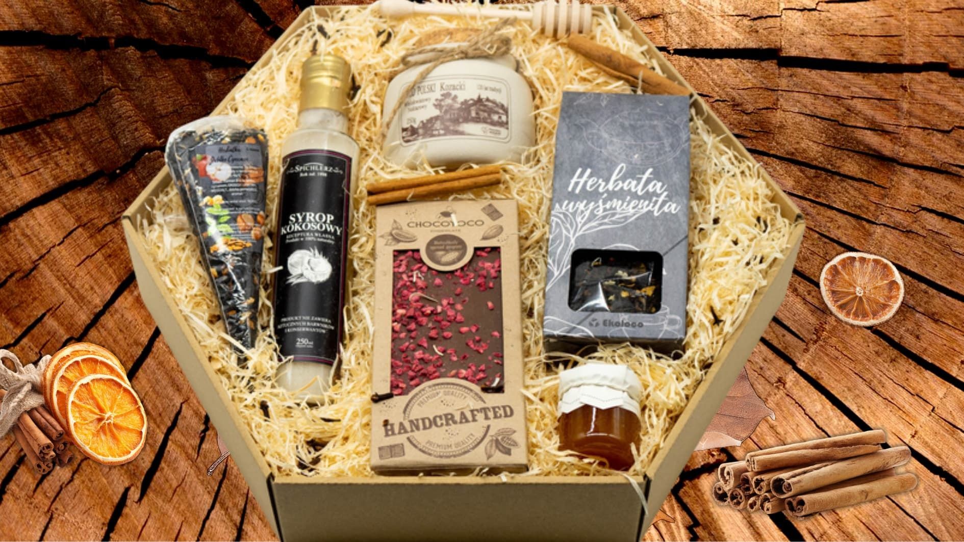 Zestaw prezentowy Q25 w opakowaniu typu plaster miodu z miodem, czekoladą, świeczką i produktami świątecznymi.